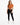 A model wearing a cropped, rust-colored top tied at the waist, paired with black leggings and white sneakers.