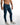 Model wearing Carbon Finn blue denim jeans and white sneakers for a modern streetwear look.