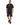 A man stands wearing a black graphic t-shirt and distressed black shorts, paired with black athletic shoes.
