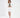 Model wearing the Nina Skirt Set in cream, featuring a cropped blazer and matching mini skirt over a green knit top.