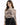 A woman models a fitted, long-sleeve top featuring intricate graphic designs and a high neckline.