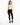 A model poses in a fitted long-sleeve top with cut-out details, paired with black skinny jeans and sneakers.