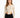 A model wearing a fitted, ribbed long-sleeve bodysuit with cut-out sides, paired with black jeans.