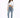 A woman stands confidently in a cropped white long-sleeve top, light blue jeans, and gray fuzzy slippers.