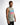 A man wearing a sleeveless light green shirt with colorful "GAME OVER" graphic design, posing against a white backgro...