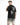 A man wearing a black t-shirt with a graphic design featuring a devilish cherub and a skull on the back.