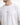 A close-up of a man wearing a white oversized t-shirt featuring a minimalist text design on the front.