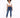 A model poses in a cropped white top and fitted blue jeans, paired with white sneakers against a light background.