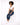 A model with curly hair sits on a white pedestal, wearing a cropped white top and dark blue jeans with white sneakers.
