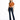 A woman stands confidently in a tied, rust-colored top and dark flared jeans, paired with black heels.