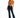 A woman poses in a cropped, rust-colored top tied at the waist, paired with dark flared jeans and heels.