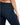 Close-up of a person wearing dark blue denim jeans, highlighting the back pocket and fitted silhouette.