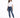 A woman stands confidently in a casual white t-shirt and distressed blue jeans, paired with white sneakers.