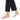 A bare foot with a delicate gold anklet featuring colorful charms, paired with black cropped pants.