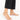 Delicate gold anklet with colorful beads, worn on a bare foot against a white background.