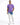 A man stands confidently in a purple t-shirt and light blue, distressed jeans with a tie-dye effect.