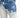 Faded blue jeans featuring a distressed design with light and dark wash contrasts.