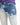 Faded blue jeans featuring a distressed design with light and dark wash contrasts.