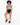 A model with curly hair sits on a white cube, wearing a patterned bodysuit and black high-waisted shorts.