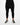 Black tapered pants with a belted waist, paired with black and white sneakers on a neutral background.