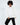Model in Ari oversized white crewneck sweatshirt with QUstyle patch and black pants against a white background.