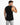 A man in a sleeveless black top poses with his back to the camera, showcasing a casual style.