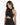 A woman in a sparkly black halter top with a cutout design, showcasing a stylish and modern look.