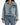 A model wearing a cropped denim jacket with a zip front and a chest pocket, paired with light blue jeans.