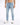 Light blue skinny jeans with distressed details, paired with white athletic shoes, worn by a male model.
