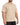 A man is wearing a short-sleeve, beige t-shirt paired with dark jeans, showcasing a casual style.