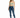 A woman stands confidently in a light green crop top and distressed blue skinny jeans, paired with white sneakers.