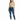 A woman stands confidently in a light green crop top and distressed blue skinny jeans, paired with white sneakers.