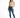 A woman stands confidently in a light green cropped top, distressed blue jeans, and white sneakers with green accents.