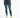 A woman wearing a cropped green top and distressed blue skinny jeans, paired with white sneakers featuring neon accents.
