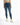A woman wearing a cropped green top and distressed blue skinny jeans, paired with white sneakers featuring neon accents.