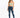 A model wearing a light green cropped top with spaghetti straps paired with distressed blue jeans and white sneakers.