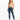 A model wearing a light green cropped top with spaghetti straps paired with distressed blue jeans and white sneakers.