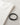 A black bracelet with a sleek clasp rests beside a folded white shirt on a textured surface.