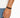 A close-up of a hand wearing a double-stranded brown bracelet with a black clasp.