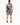 A man stands with his back to the camera, wearing a short-sleeve shirt and matching shorts featuring a black and whit...