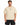 A man wearing a beige oversized t-shirt with a graphic design, paired with black shorts.