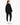 A woman stands with her back to the camera, wearing a black oversized sweatshirt and matching joggers with white snea...