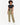 A model wearing loose-fitting olive green pants paired with a black crop top and white sneakers.