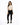 A model poses in a fitted beige long-sleeve top with cut-out details, paired with black skinny jeans and sneakers.