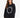 A woman with long, wavy hair wears a black oversized sweatshirt featuring a circular text design in white.