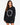 A woman with long, wavy hair wears a black oversized sweatshirt featuring a circular text design in white.