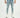 Men's light blue super jeans with distressed details and ripped knees on a model wearing white sneakers.