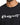 A close-up of a black t-shirt featuring a stylish white script design on the front.