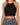 Black crochet halter top featuring intricate patterns and a scalloped hem, paired with a patterned skirt.