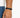 A close-up of a hand wearing a black braided bracelet with a sleek metal clasp, showcasing a minimalist design.